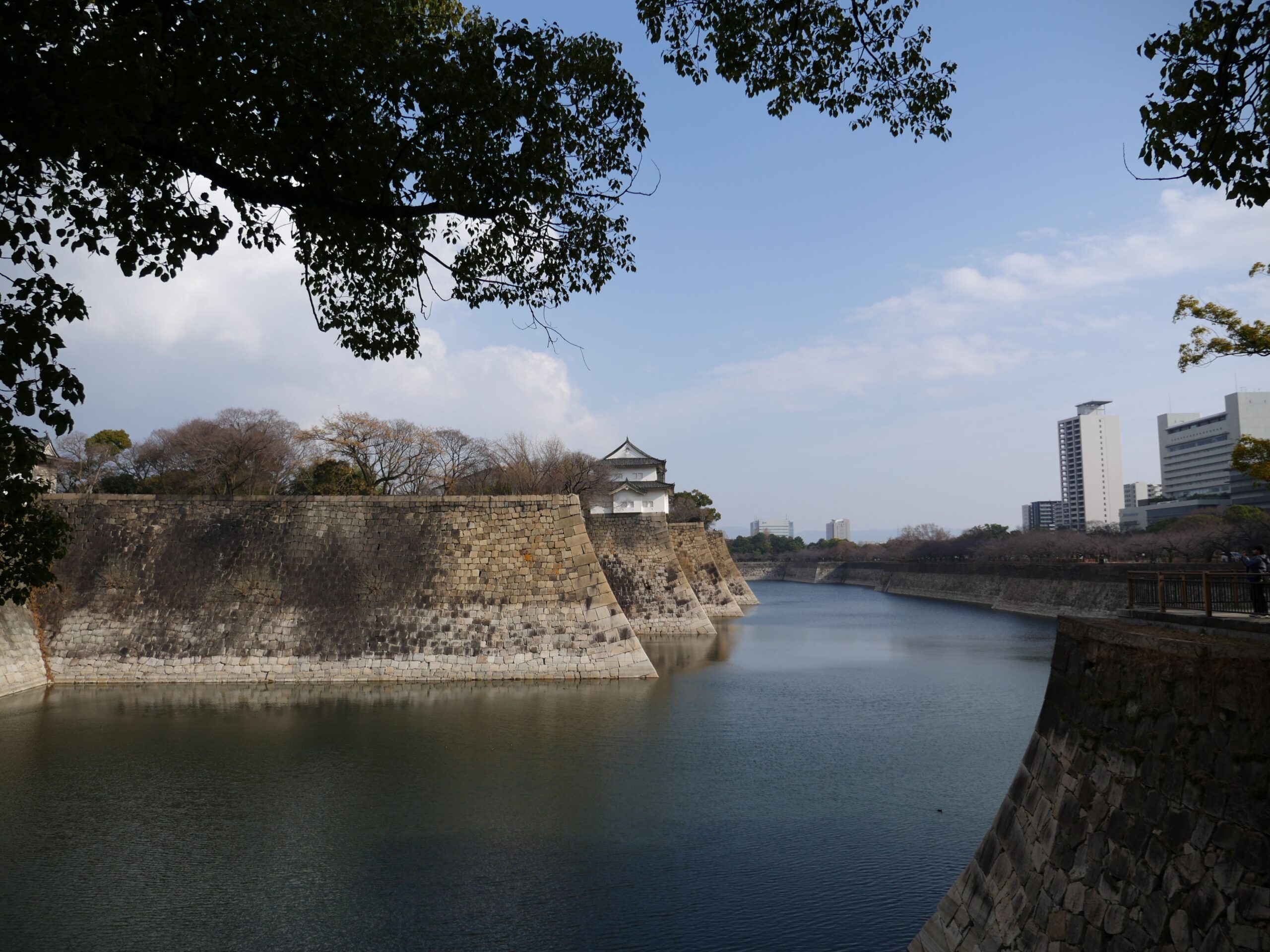 Stone walls rise up from a large moat outside Osaka Castle.