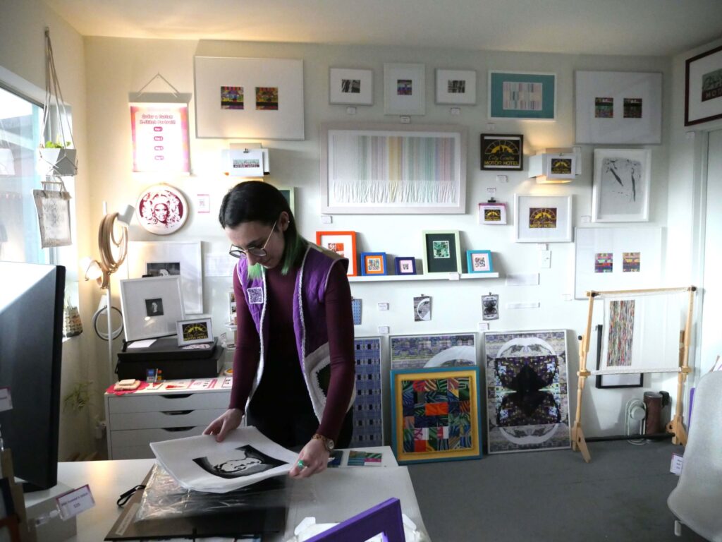 Artist Mallory Donen stands by the desk in her studio.